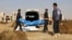 FILE - This frame grab from a video provided on Nov. 22, 2018, shows Syrian workers of a Raqqa group carrying human remains at the site of a mass grave believed to contain the bodies of civilians and Islamic State militants, in Raqqa. 