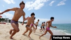 강원 동해안 92개 해수욕장이 개장한 8일 강릉 경포해수욕장에서 수상인명 구조요원들이 바다에 뛰어들고 있다.