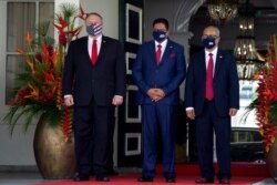 U.S. Secretary of State Mike Pompeo, left, stands next to Surinam's President Chan Santokhi, center, and Surinam's Minister of Foreign Affairs Albert Ramdin at the presidential palace in Paramaribo, Sept. 17, 2020.