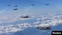 U.S. Marine Corps F-35B fighter jets (front) and South Korean air Force's F-15K fly over South Korea during a joint military drill, South Korea, Aug. 31, 2017.