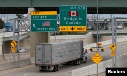 Trucks headed for Windsor, Ontario, exit onto the lane towards the Ambassador bridge in Detroit, Michigan, April 26, 2017.