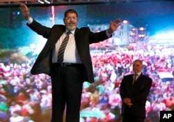 In this May 20, 2012 file photo, then Muslim Brotherhood's presidential candidate Mohammed Morsi holds a rally in Cairo, Egypt. (AP Photo/Fredrik Persson, File)