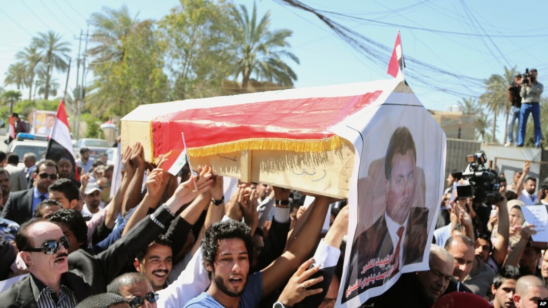 Para pelayat berpawai di Baghdad membawa peti berisi jenazah Mohammed Bdaiwi Owaid al-Shammari, pimpinan Radio Free Iraq biro Baghdad.