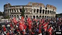 Para demonstran Italia melewati monumen 'Colosseum' di Roma saat pemogokan umum para pekerja di Italia (6/9).