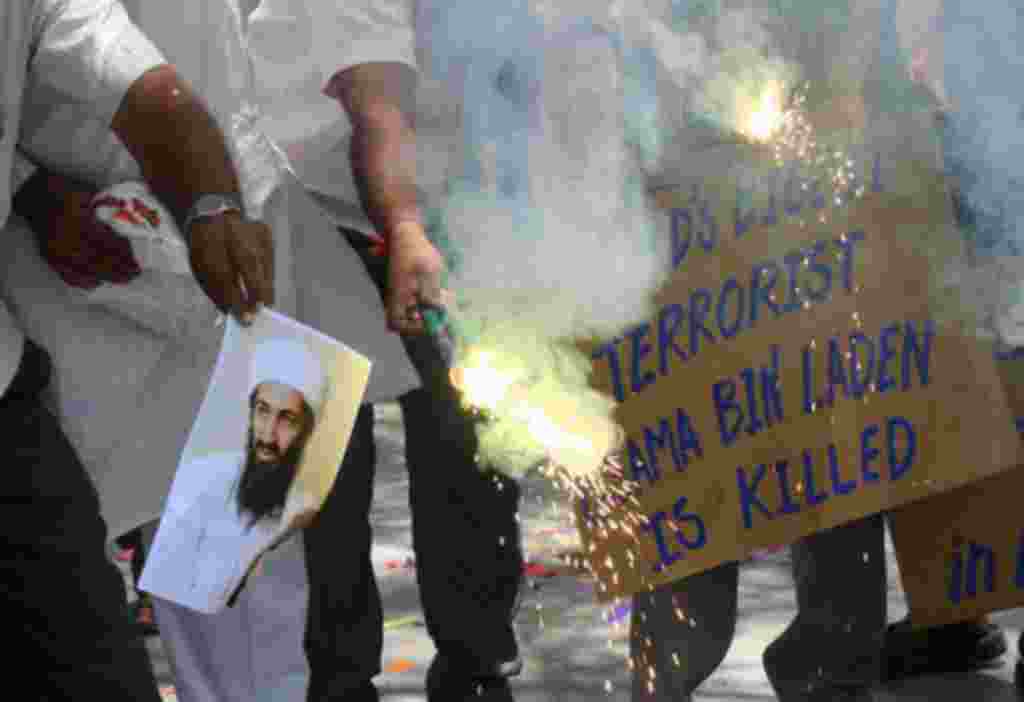 La gente quema una fotografía de Al Qaeda, Osama bin Laden, mientras celebran su muerte, en la ciudad occidental india de Ahmedabad.