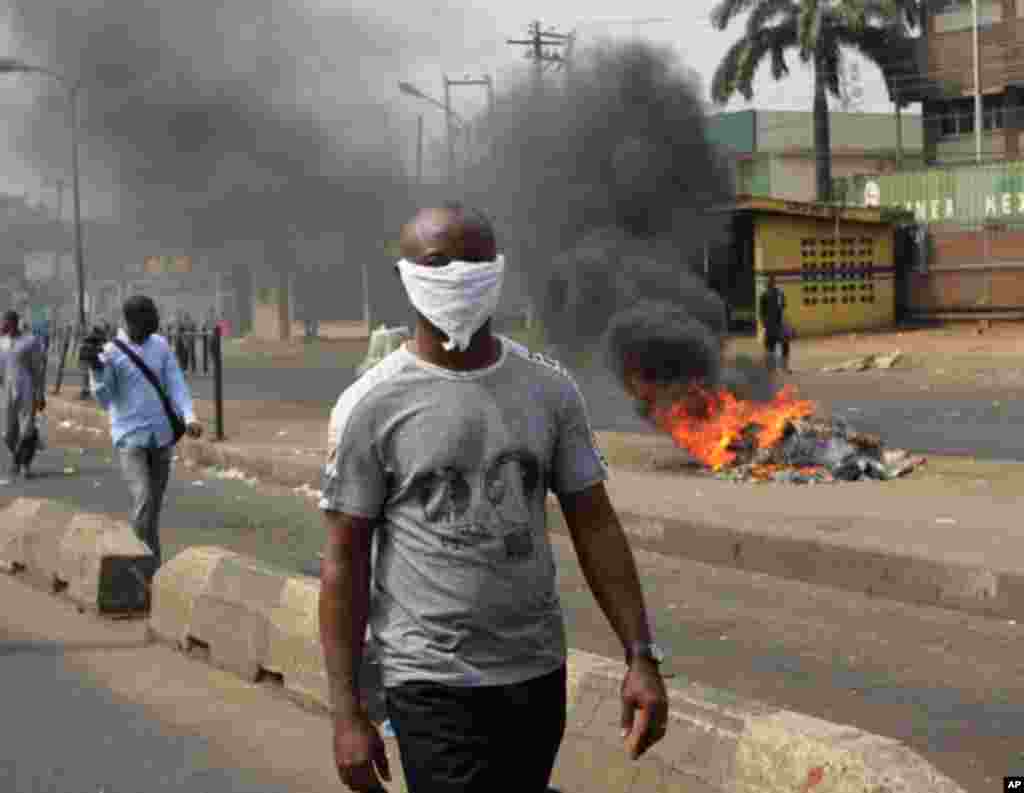 A man walk past a fire during a protest against the removal of fuel subsidy in Lagos ,Nigeria, on January 9, 2012. (AP)