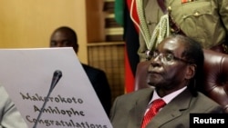 Zimbabwe's President Robert Mugabe reads a card during his 93rd birthday celebrations in Harare, Zimbabwe, Feb. 21, 2017. 