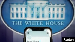 A photo illustration shows the suspended Twitter account of U.S. President Donald Trump on a smartphone at the White House briefing room in Washington, D.C., Jan. 8, 2021.