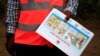 An Ugandan health worker shows an informational flyer on Ebola virus and how to prevent its spread to the community of Kirembo village, near the border with the Democratic Republic of Congo, in Kasese district, Uganda, June 15, 2019. 