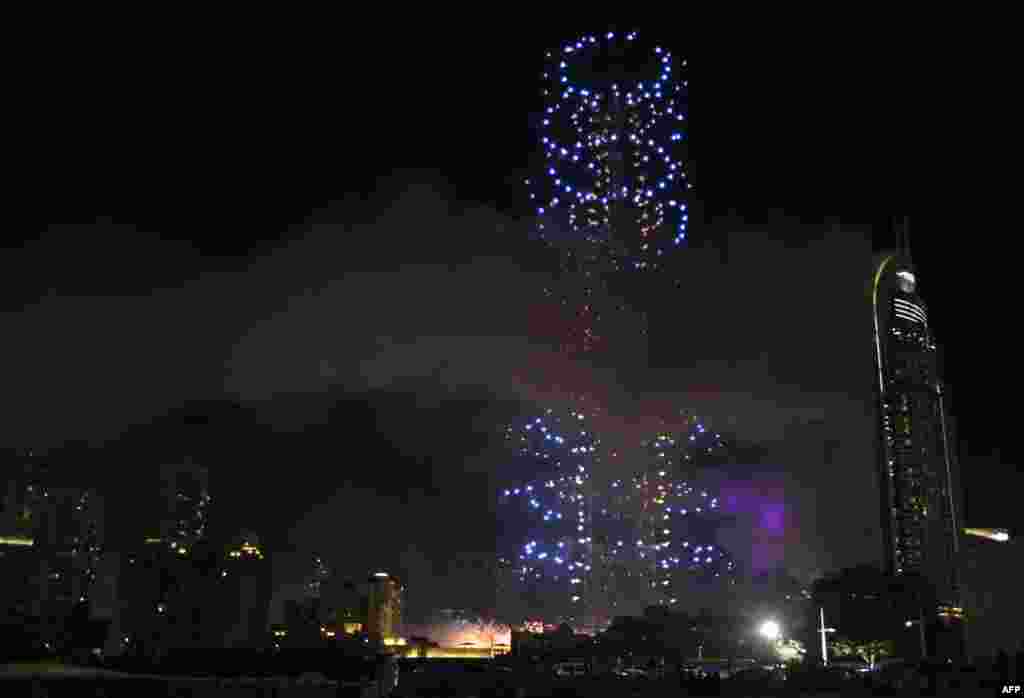 Fireworks explode during New Year&#39;s celebrations over Dubai&#39;s Burj Khalifa, the world&#39;s tallest tower, close to where flames were still billowing from the 63-story Address Downtown hotel, Jan. 1, 2016. Flames rip through the hotel after it was hit by a massive fire hours and more than a dozen people were injured.