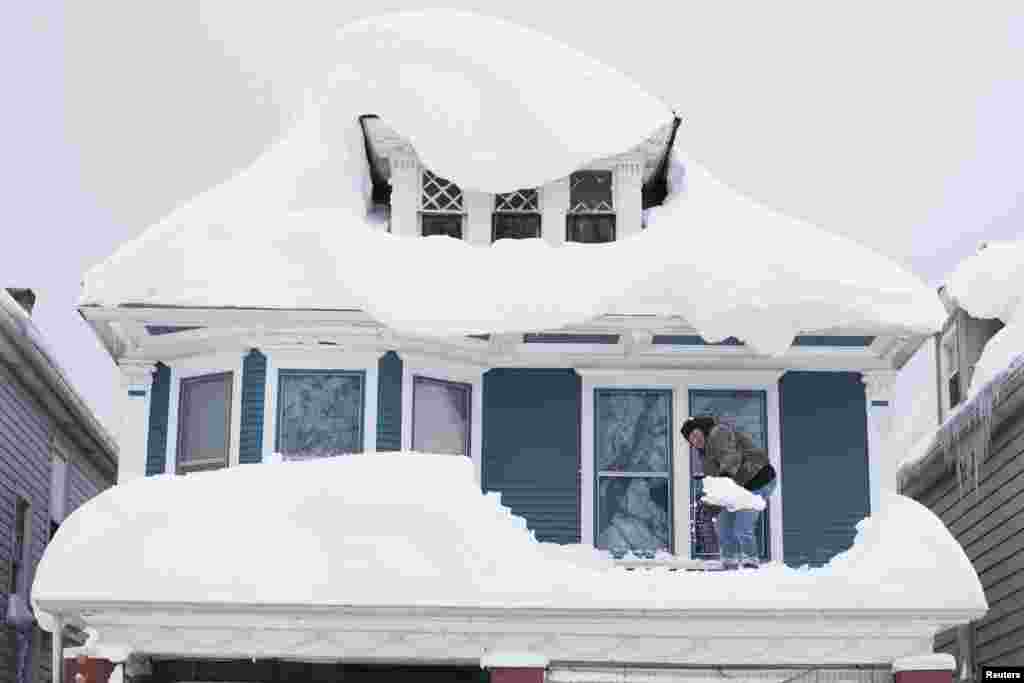 Tom Wilczak shovels snow from the roof of his home following a storm in Buffalo, New York, Nov. 20, 2014. 