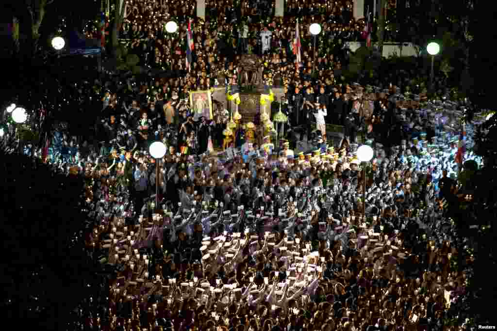 Mourners hold candles at the Siriraj Hospital during a vigil in Bangkok, Thailand.