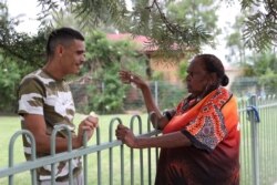 Rita Wright, tetua suku Muruwari, anggota "Generasi yang Terampas" berbincang-bincang dengan keponakannya, David Marne, di dekat rumah mereka di Sydney, Australia, 19 Januari 2021. (Foto: Reuters)