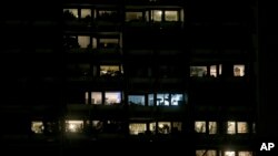FILE - Apartments are illuminated in a building in Vienna, Austria, March 28, 2020. Incidents of domestic violence have gone up during coronavirus shutdowns.
