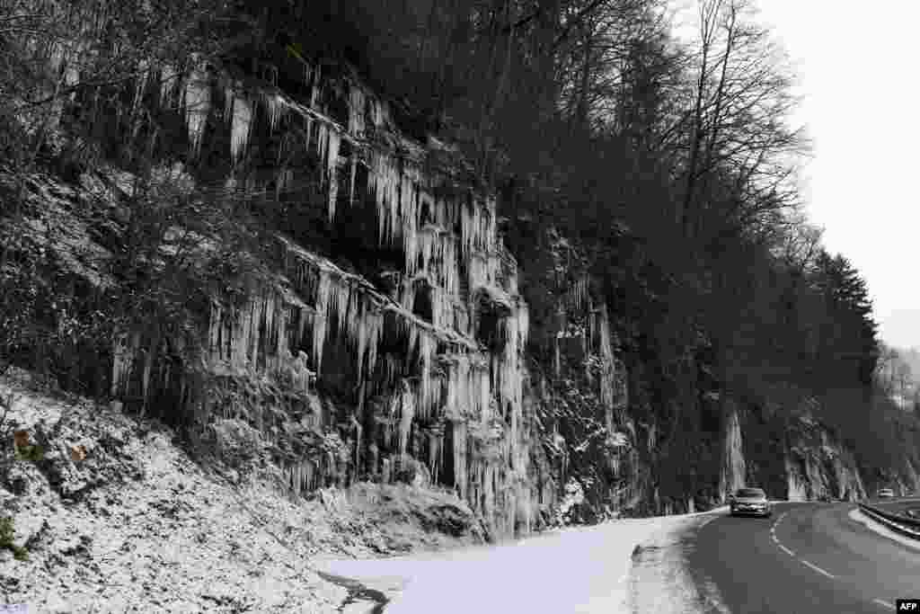 &nbsp;قندیل های یخ آویزان از صخره های کوهستانی آلپ در حاشیه جاده ای فرانسه &nbsp;