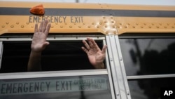 FILE - Exiled Nicaraguans released from a Nicaraguan jail wave from a bus after arriving at the airport in Guatemala City, Sept. 5, 2024.