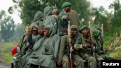 Congolese armed forces (FARDC) soldiers ride on their pick-up truck as they advance to a new position while battling M23 rebels in Kibati near Goma, in the eastern Democratic Republic of Congo, Sept. 2, 2013.