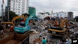 Rescatistas tratan de retirar los escombros en el lugar donde colapsó un edificio en la provincia de Preah Sihanouk, Camboya, el domingo 23 de junio de 2019. (AP Foto/Heng Sinith)