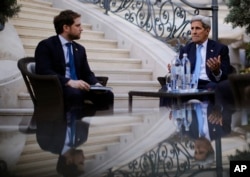 U.S. Secretary of State John Kerry, right, and State Department Chief of Staff Jon Finer, left, meet with members of the U.S. delegation at the garden of the Palais Coburg hotel in Vienna, Austria, July 10, 2015.