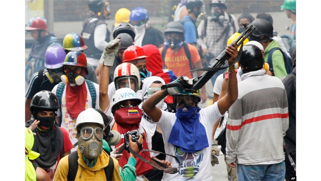 An anti-government demonstrator shows a shotgun taken from security forces during clashes in Caracas, Venezuela, May 8, 2017.