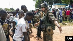 French troops of the Sangaris operation stop the crowds who have gathered at the entrance to the airport of Bangui, Central African Republic on Dec. 12, 2013.