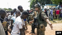 Des civils centrafricains discutent avec des militaires français de l'opération Sangaris à Bangui, 12 décembre 2013.