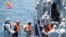 Migrants walk aboard the Italian navy ship Scirocco during a rescue operation about 40 nautical miles off the coast of Libya in this handout picture released on June 14, 2014 by the Italian Marina Militare. 