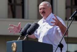 FILE - Belarus' President Alexander Lukashenko gestures as he delivers a speech during a rally held to support him in central Minsk, Aug. 16, 2020.