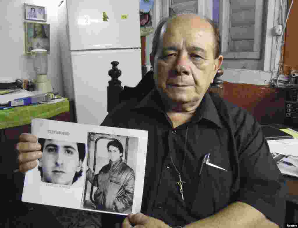 Raul Borges, 74, holds a picture of his son Ernesto Borges, a KGB-trained counter-intelligence officer who has been in a Cuban prison for 16 years. His case, along with others, is now in the spotlight after Cuba agreed to free 53 political prisoners.