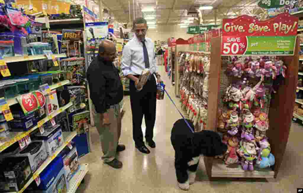 U.S. President Barack Obama buys a bone for his dog Bo (R) in Alexandria, Virginia December 21, 2011. Obama was in Alexandria doing some Christmas shopping and stopped in a pizzeria for lunch. REUTERS/Kevin Lamarque (UNITED STATES - Tags: POLITICS AN