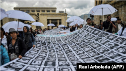 Fotos de desaparecidos y víctimas del conflicto armado en Colombia, expuestas frente al Teatro Colón, donde se desarrolla la ceremonia por el aniversario de la firma de la paz entre las FARC y el gobierno, el 24 de noviembre de 2017.