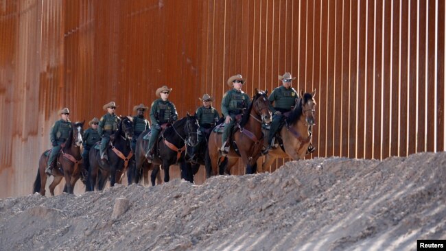 美国一支边境巡逻队沿着边境墙巡逻