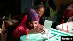 Lydia Gathoni, âgée de 102 ans, glisse son bulletin dans l'urne lors de l'élection présidentielle à Gatundu, Kenya, le 8 août 2017.