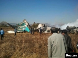 FILE - People gather at the wreckage of a Air Bagan Fokker-100 passenger jet that crashed in Heho, Myanmar, Dec. 25, 2012.