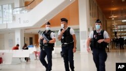 Policías franceses patrullan los pasillos de un tribunal de París en el segundo día del juicio por los ataques terroristas de 2015, el 3 de septiembre de 2020.