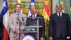 Dominican Republic President Danilo Medina, center, addresses the press alongside Jose Luis Rodriguez Zapatero, former prime minister of Spain, left, and Miguel Vargas, Dominican Republic foreign minister, after a long day of negotiations aimed at resolving Venezuela's ongoing economic and political crisis, at the Foreign Affairs Ministry in Santo Domingo, Dominican Republic, Dec. 1, 2017. Medina said Feb. 7, 2018, that the talks had entered an "indefinite recess."