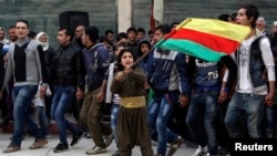 Một cậu bé người Kurd vui mừng vẫy cờ vì thắng lợi trước Nhà nước Hồi giáo ở Kobani. 