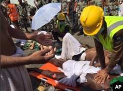 In this image posted on the Twitter account of the directorate of the Saudi Civil Defense agency, a pilgrim is treated by a medic after a stampede near the holy city of Mina during the annual hajj pilgrimage, Sept. 24, 2015.