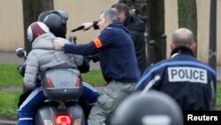 Policías frances arrestan a dos jóvenes en una motocicleta cuando se acercaban a la zona donde un atacante ha tomado rehenes en un supermercado judío en el este de París.