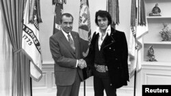 Presiden AS Richard Nixon berjabat tangan dengan Elvis Presley di Ruang Oval, Gedung Putih, Desember 1970.