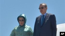 Perdana Menteri Turki, Recep Tayyip Erdogan,didampingi istrinya Emine Erdogan, saat mendarat di bandara Aljazair, 4 Juni 2013 (Foto: dok). PM Erdogan telah kembali ke negaranya seusai melakukan lawatan ke beberapa wilayah di Afrika Utara, di tengah aksi-protes warga yang menuntut pengunduran dirinya dari jabatan sebagai Perdana Menteri.