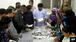 Pakistani election staff count the votes after polls closed at a polling station for the parliamentary elections in Karachi, Pakistan, July 25, 2018.