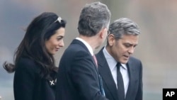 U.S. actor George Clooney, right, and his wife Amal Clooney, left, are accompanied by Merkel's foreign policy advisor Christoph Heusgen as they leave chancellery after private meeting with German chancellor Angela Merkel in Berlin, Germany, Feb. 12, 2016.