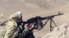 FILE - A member of the Taliban aims his machine gun at the front line in Charasyab, approximately 20 km from Kabul, Afghanistan, Feb. 18, 1995. 