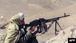 FILE - A member of the Taliban aims his machine gun at the front line in Charasyab, approximately 20 km from Kabul, Afghanistan, Feb. 18, 1995. 