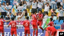 Para pemain sepakbola Korea Utara dalam pertandingan melawan China di Asian Games Incheon, Korea Selatan (15/9). (AP/Dita Alangkara)