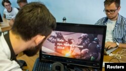 Staff members of New Cave Media test a virtual reality simulator in their office in Kyiv, Ukraine, Sept. 11, 2018. The simulator provides a VR reconstruction of the 2013-14 demonstration in Ukraine, when dozens of protesters were killed in the final moments of Viktor Yanukovich's rule. 