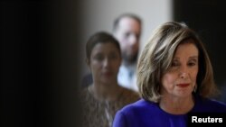 La Presidenta de la Cámara de Representantes de los Estados Unidos, Nancy Pelosi camina al Estudio de Televisión de la Cámara de Representantes con los miembros del personal antes de hacer declaraciones en una conferencia de prensa en el Capitolio.