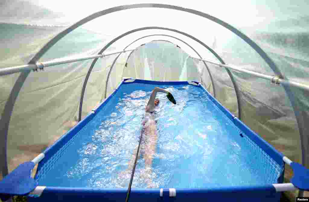 Iman Avdic, national multiple swimming record holder, maintains her form by practicing in a small plastic pool inside an improvised greenhouse in her grandfather's orchard in Doboj, Bosnia and Herzegovina, April 23, 2020.