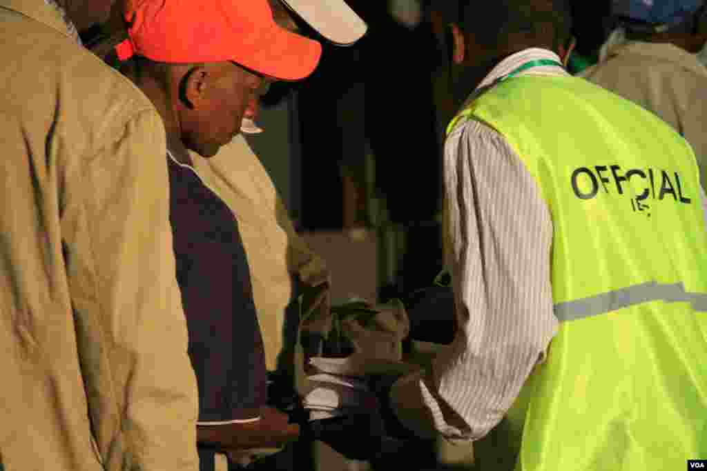 Election officials check voters&rsquo; cards at the Mutomo Primary School, where voting for the Gatundu constituency took place, March 4, 2013. (J. Craig/VOA)